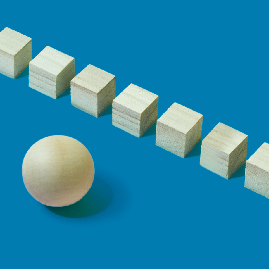 A row of stacks of paper with a big sphere in front of them on a blue background